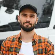 male-driver-with-clipboard-near-big-truck-outdoors